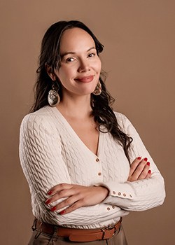 Woman with long dark hair smiling and wearing a cream v-neck sweater.